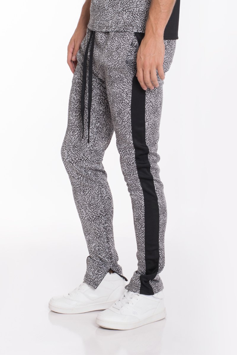 Black elephant print pants featuring a two-tone color block design and ankle zippers, perfect for casual wear.