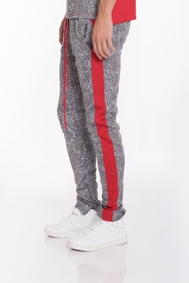 Red elephant print pants featuring a two-tone color block design, ankle zippers, and lightweight fabric, perfect for casual wear.