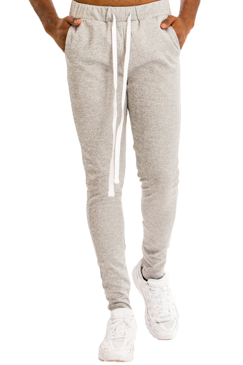 Essentials Track Pant in solid color with elastic waist and hidden ankle zipper, showcasing a modern skinny fit.