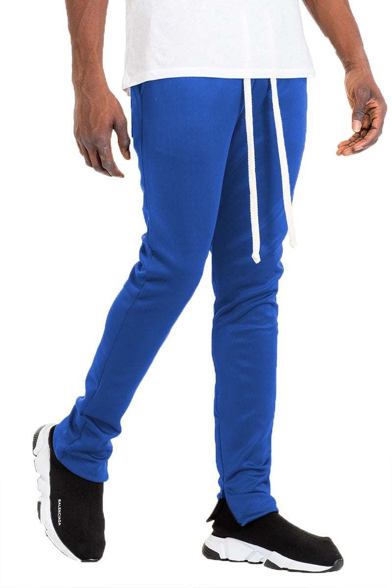 Essentials Track Pant in solid color with elastic waist and hidden ankle zipper, showcasing a modern skinny fit.