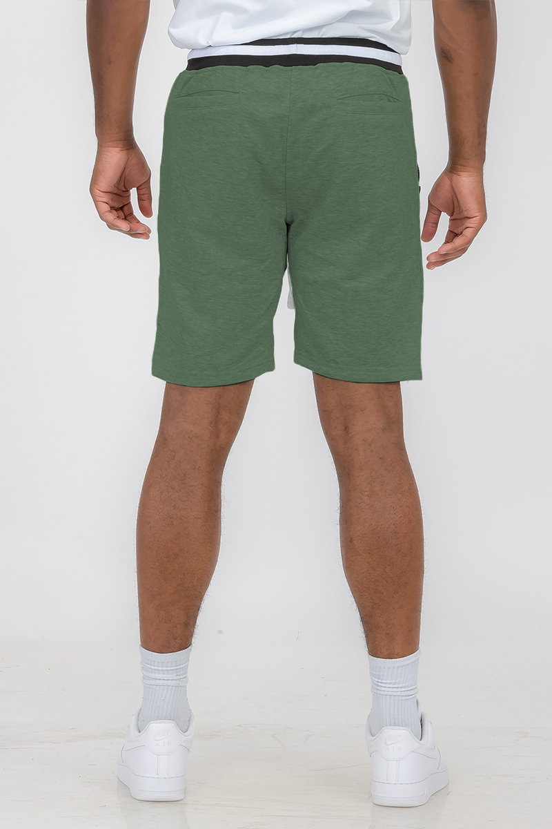 Man wearing green shorts, sneakers.