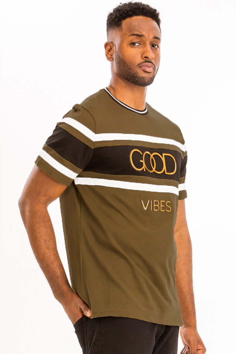 A model wearing the GOOD VIBES TEE, showcasing its comfortable fit and stylish design in a casual setting.