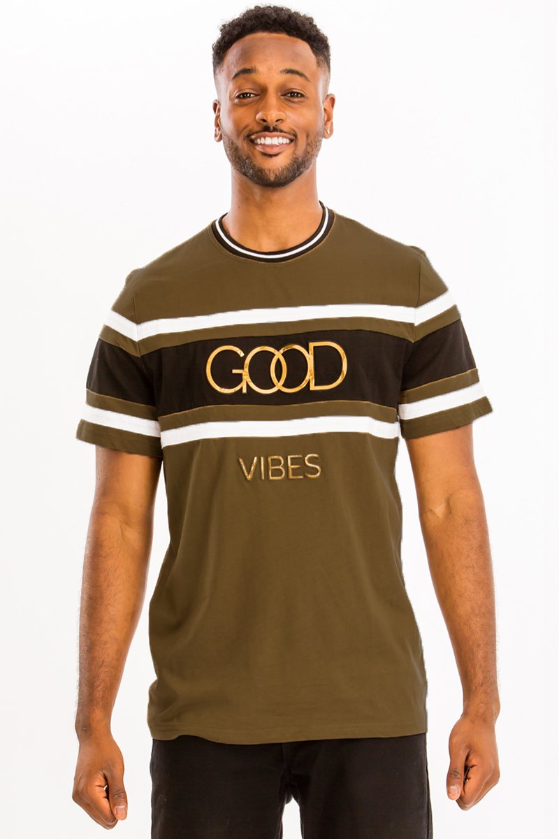 A model wearing the GOOD VIBES TEE, showcasing its comfortable fit and stylish design in a casual setting.