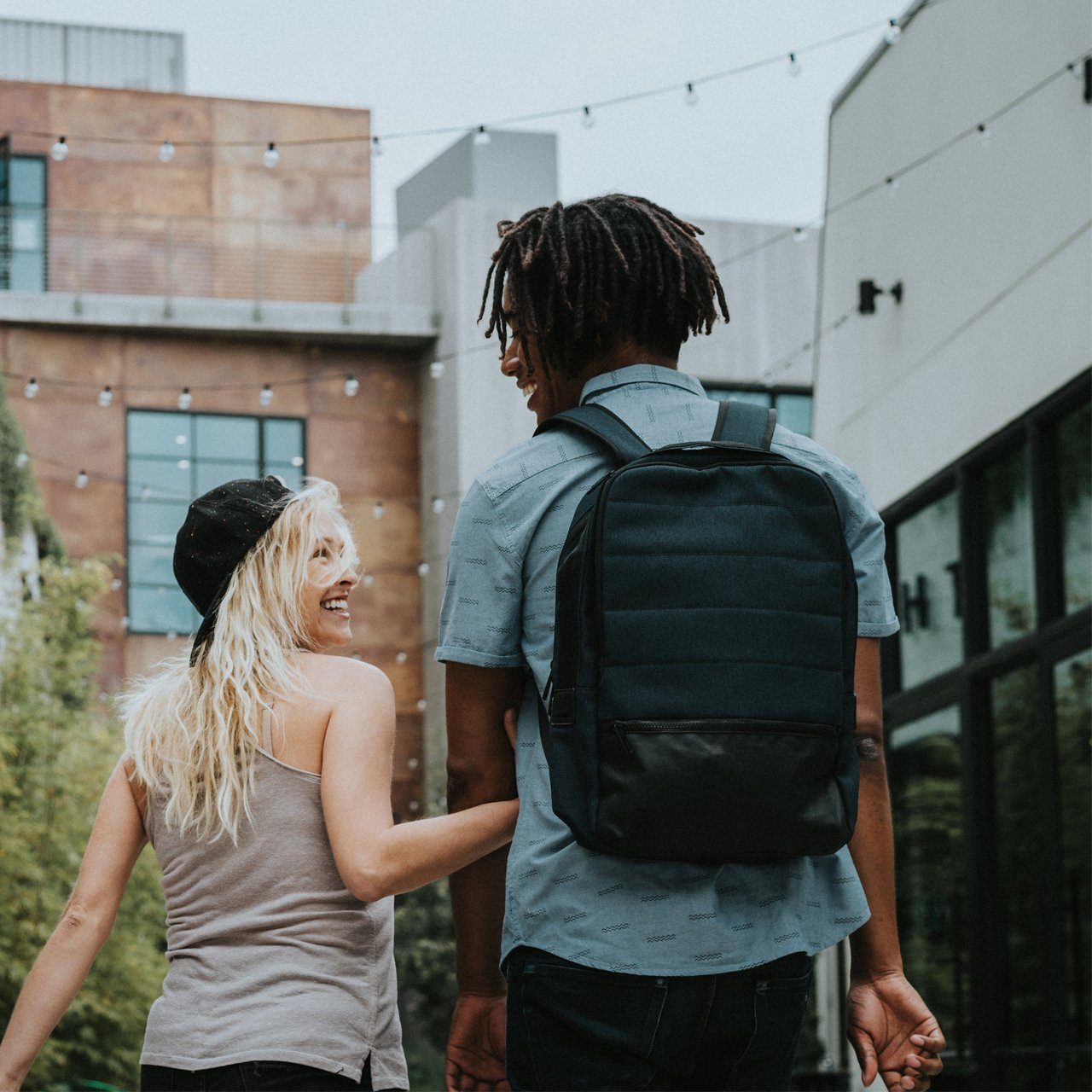 Hank Backpack in multiple colors, featuring padded straps and a laptop sleeve, ideal for school and travel.