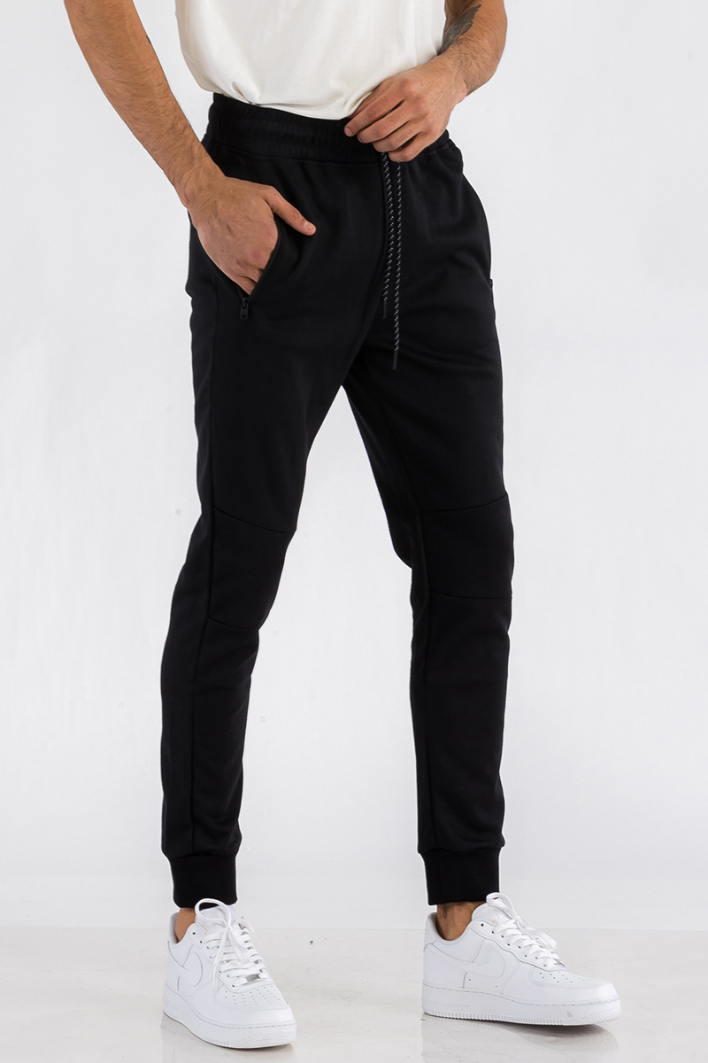 Heathered cotton sweats featuring an elastic waist, ankle cuffs, and a zipper pocket, displayed on a model.