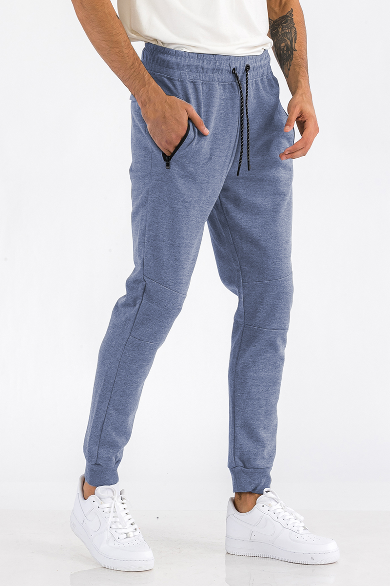 Heathered cotton sweats featuring an elastic waist, ankle cuffs, and a zipper pocket, displayed on a model.