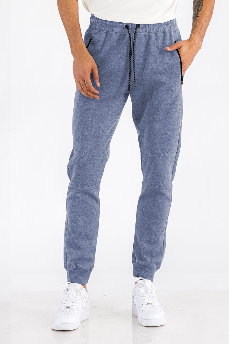 Heathered cotton sweats featuring an elastic waist, ankle cuffs, and a zipper pocket, displayed on a model.