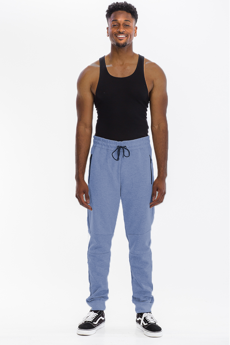 Heathered cotton sweats featuring an elastic waist, ankle cuffs, and a zipper pocket, displayed on a model.