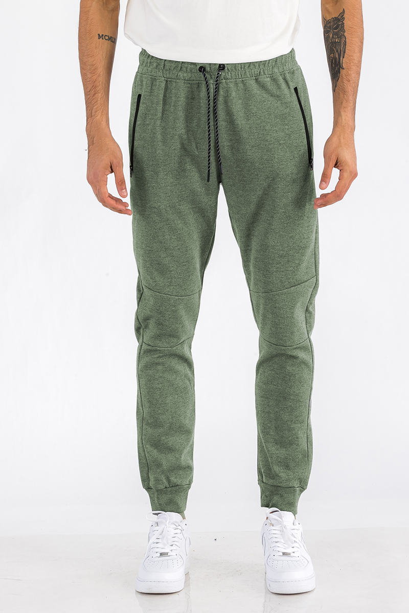 Heathered cotton sweats featuring an elastic waist, ankle cuffs, and a zipper pocket, displayed on a model.