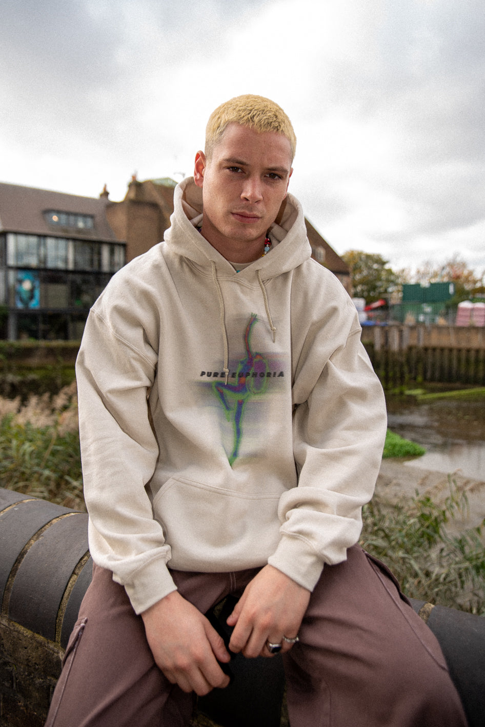 A stylish unisex sand hoodie featuring a vibrant Pure Euphoria print, showcasing its relaxed fit and heavyweight cotton material.