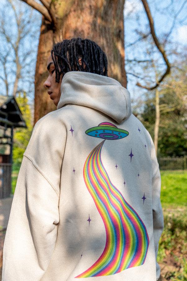 A stylish sand-colored hoodie featuring a vibrant trippy alien invasion print, perfect for casual wear and showcasing unique style.