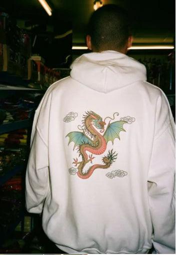 White hoodie featuring a bold Chinese dragon print on the back and brand name in traditional Chinese lettering on the front left chest.