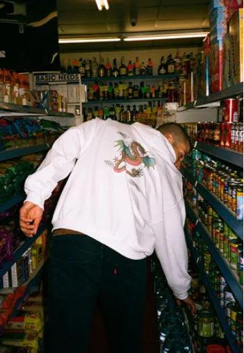 White hoodie featuring a bold Chinese dragon print on the back and brand name in traditional Chinese lettering on the front left chest.