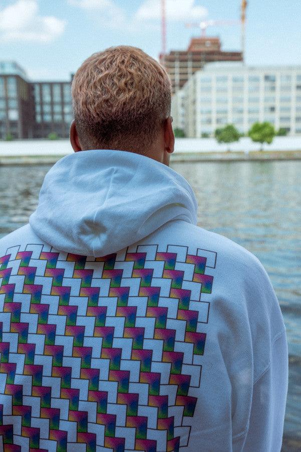 White hoodie featuring a colorful square geometric logo print on the back, showcasing a relaxed fit and soft cotton material.