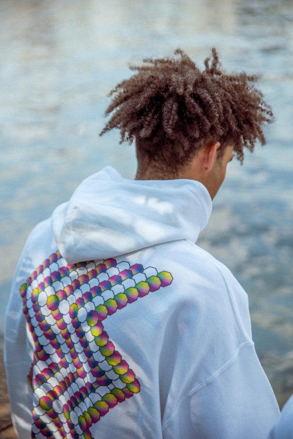 White hoodie featuring a colorful Zig-Zag geometric logo print on the back, showcasing vibrant wavy graphics.