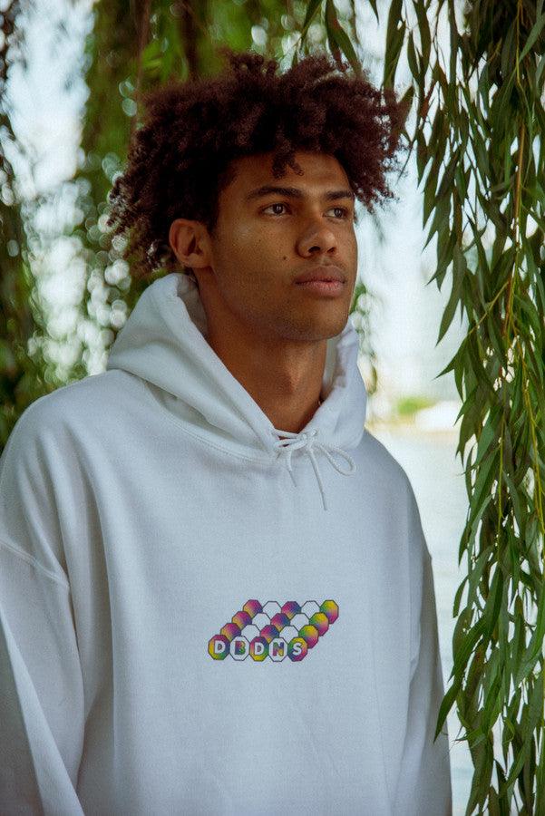 White hoodie featuring a colorful Zig-Zag geometric logo print on the back, showcasing vibrant wavy graphics.