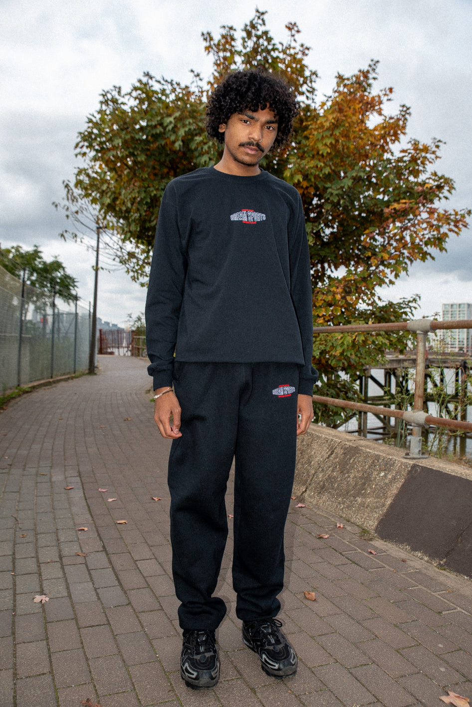 Black heavyweight joggers featuring Dream Sports embroidery, showcasing a relaxed fit and stylish design.