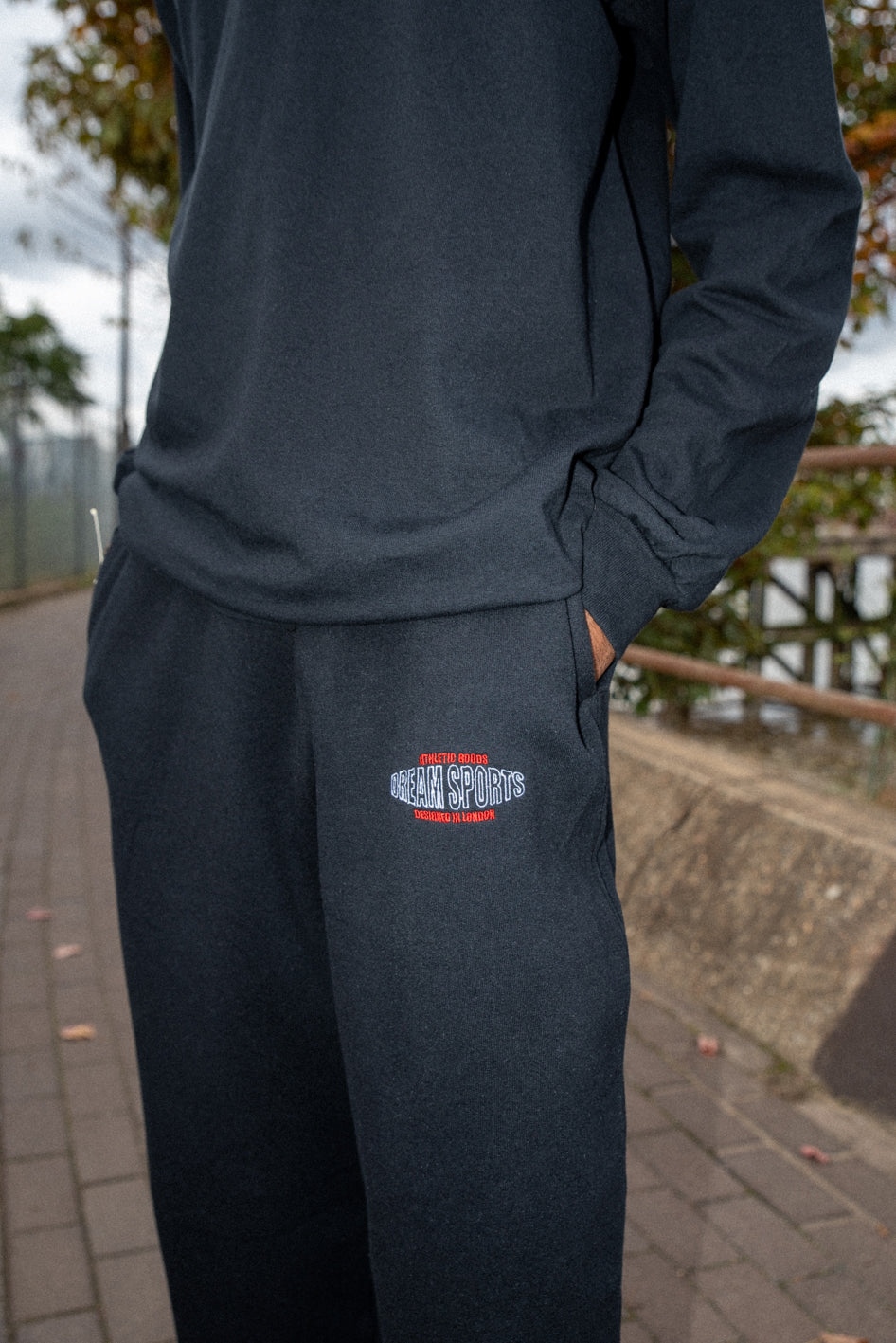 Black heavyweight joggers featuring Dream Sports embroidery, showcasing a relaxed fit and stylish design.