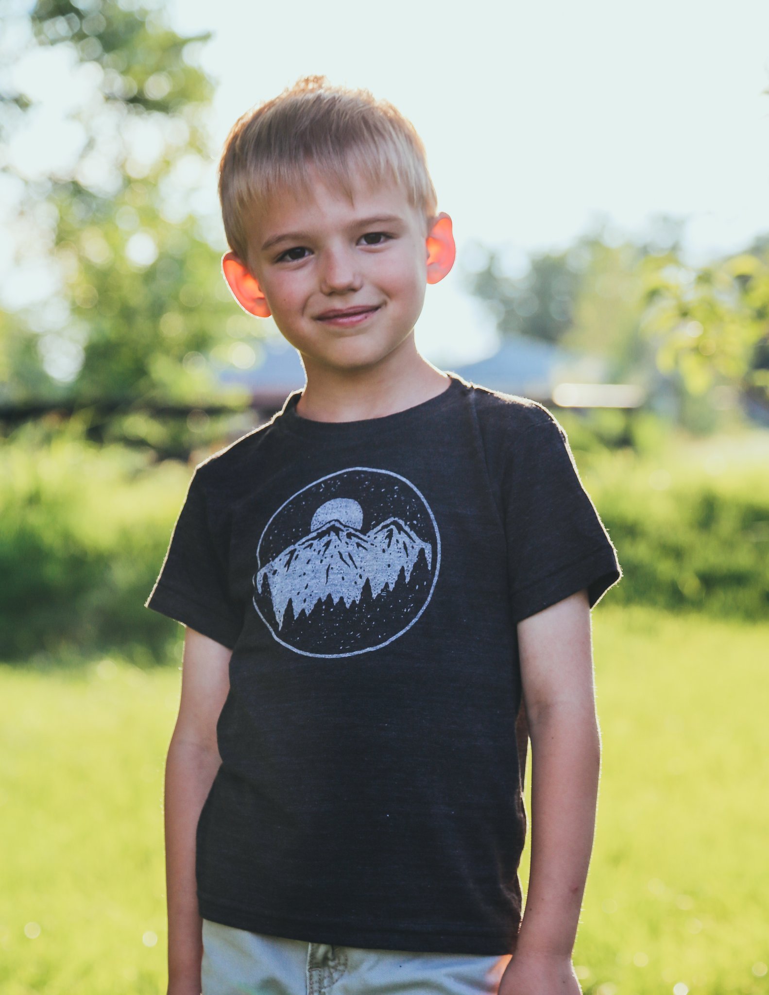 A soft gray kids graphic tee featuring a night sky design, perfect for adventurous children.