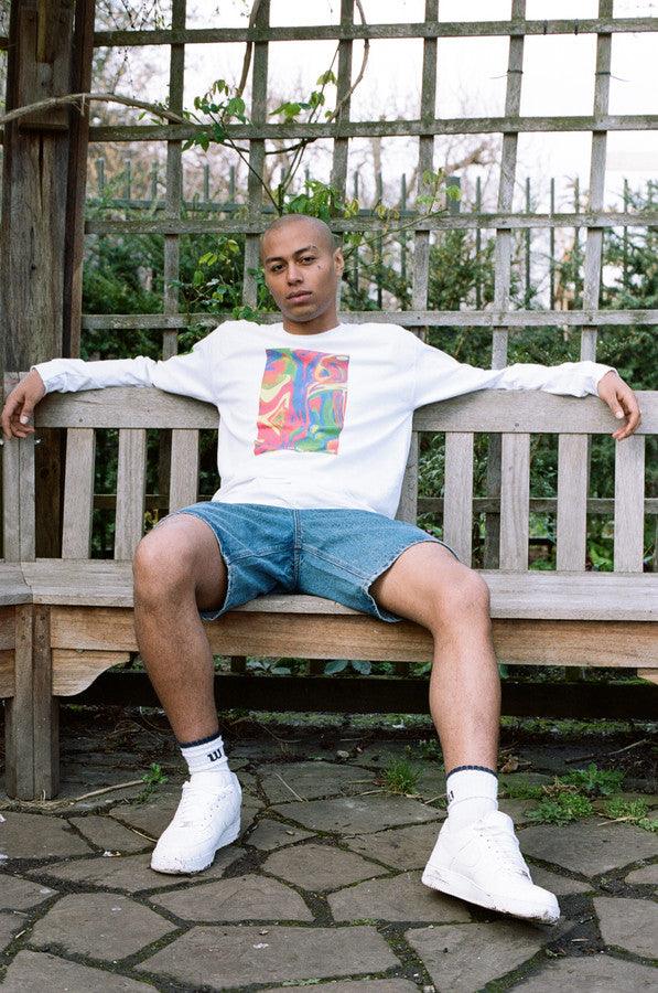 White long sleeved t-shirt featuring a vibrant trippy festival print on the front, back, and sleeves, made from soft cotton.