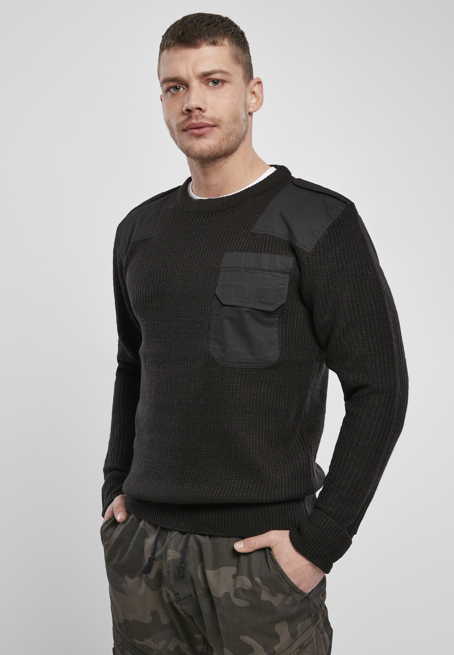 A durable Military Sweater featuring reinforced elbows and shoulders, epaulettes, and a patch chest pocket in muted colors.