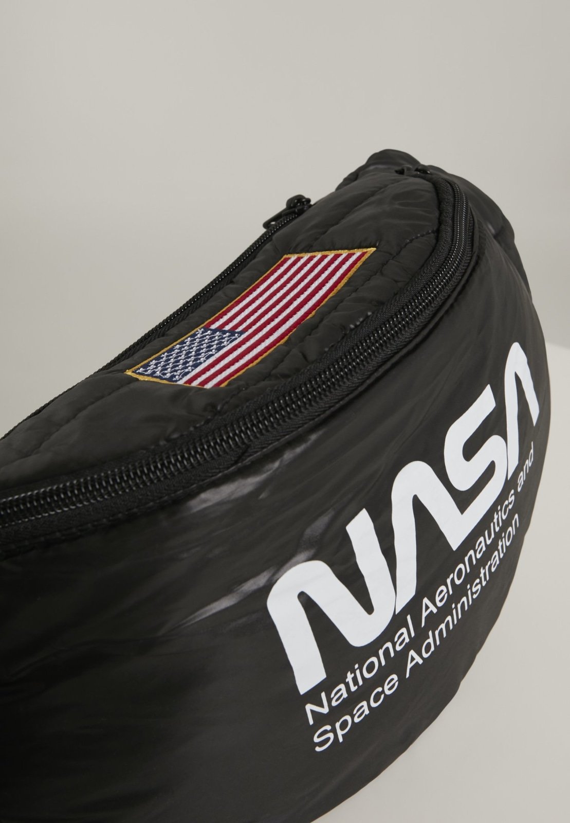 Stylish NASA Hip Bag with glossy quilted material and adjustable strap, featuring the iconic NASA emblem.