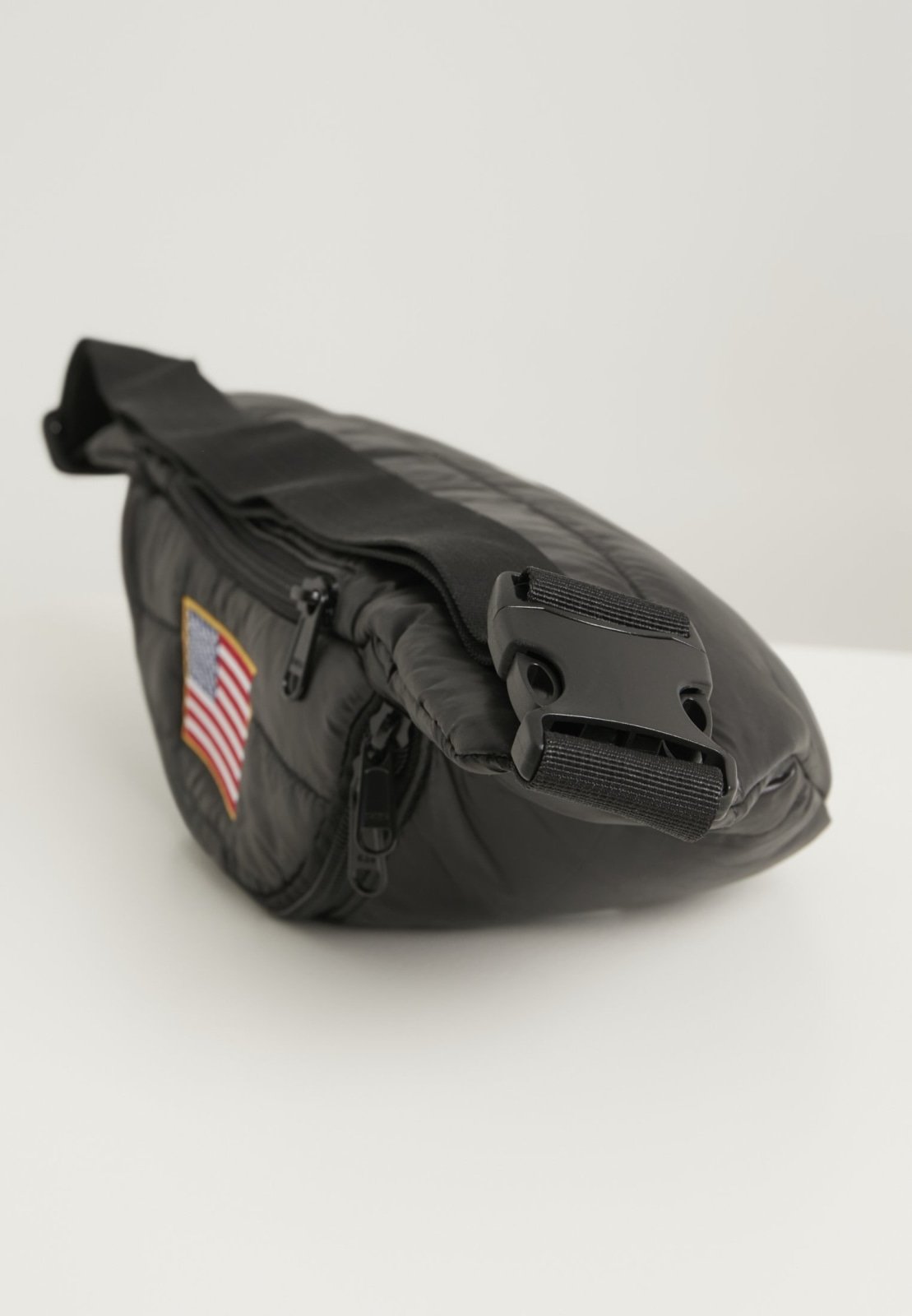 Stylish NASA Hip Bag with glossy quilted material and adjustable strap, featuring the iconic NASA emblem.