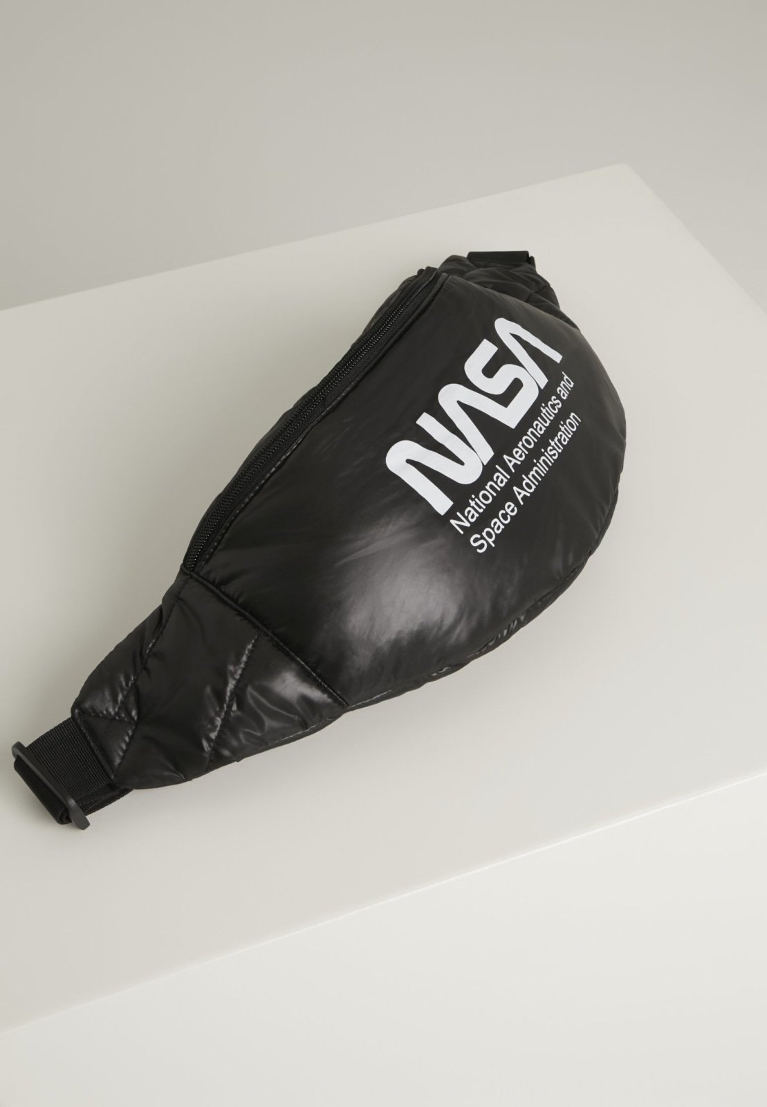 Stylish NASA Hip Bag with glossy quilted material and adjustable strap, featuring the iconic NASA emblem.