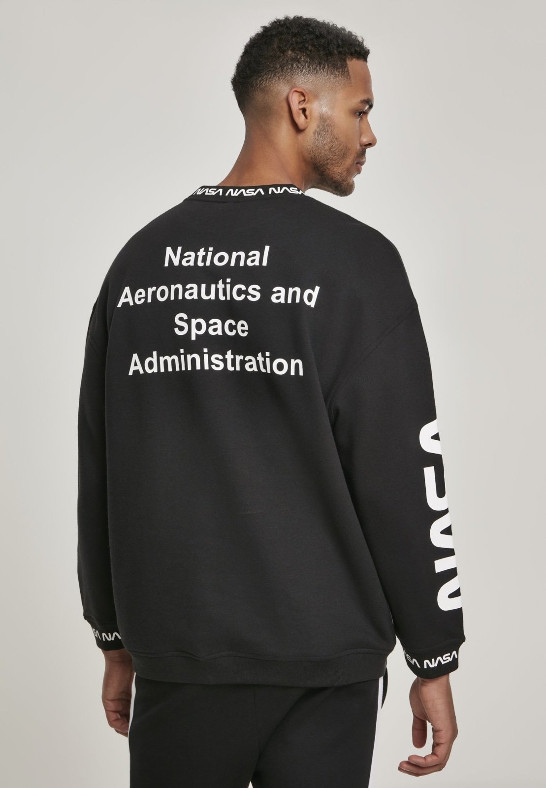 A cozy NASA Oversize Crewneck Sweater featuring logos on the sleeve and chest, perfect for space enthusiasts.