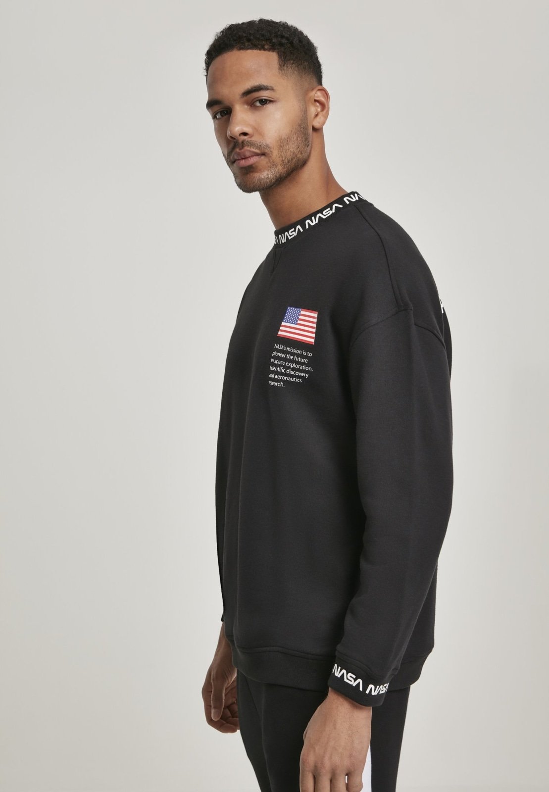 A cozy NASA Oversize Crewneck Sweater featuring logos on the sleeve and chest, perfect for space enthusiasts.