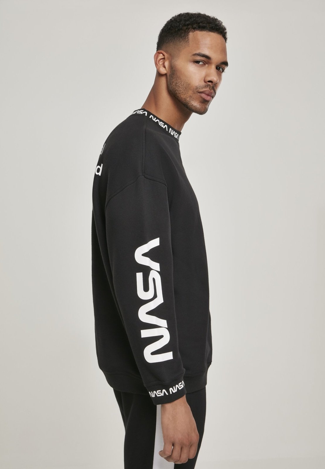 A cozy NASA Oversize Crewneck Sweater featuring logos on the sleeve and chest, perfect for space enthusiasts.