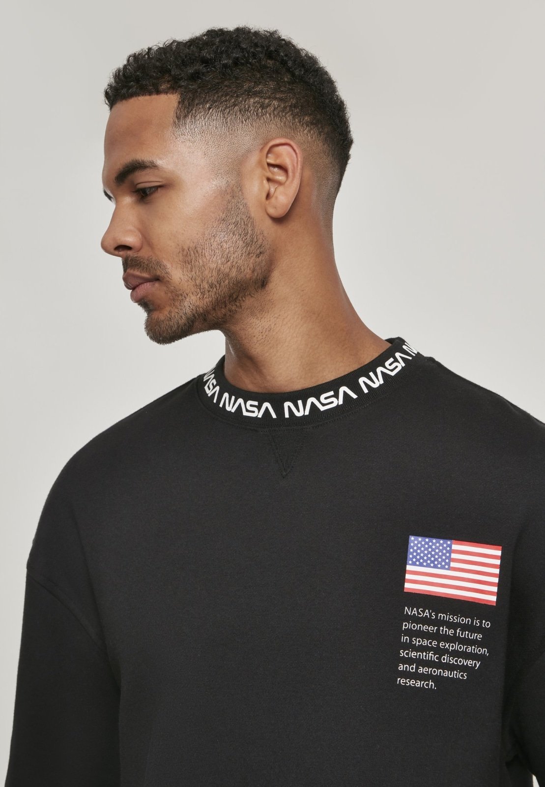 A cozy NASA Oversize Crewneck Sweater featuring logos on the sleeve and chest, perfect for space enthusiasts.