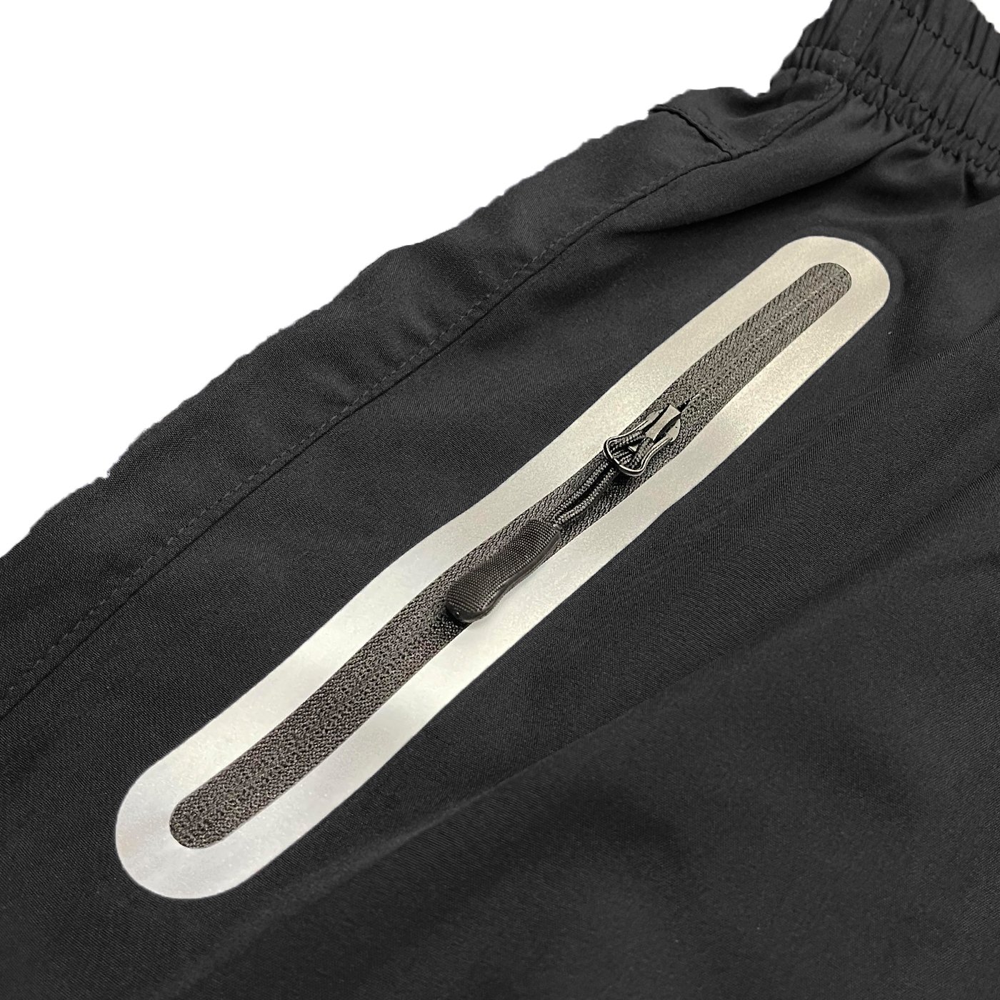 A pair of lightweight PERFORMANCE RUNNING SHORTS featuring zippered pockets and a reflective zipper, made from 100% polyester.