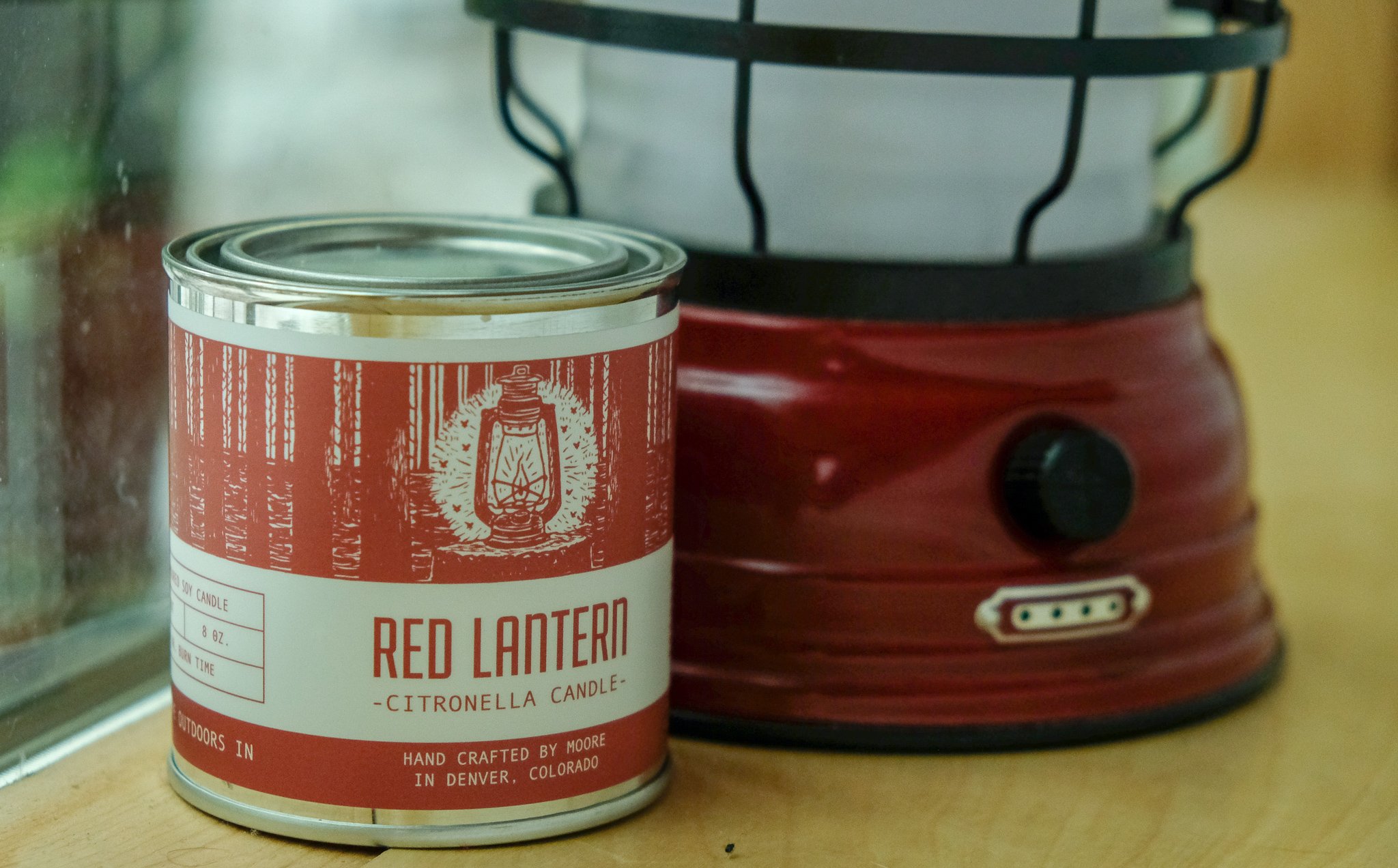 A beautifully crafted Red Lantern Citronella Candle in a vibrant red container, designed to repel insects while providing a warm glow.