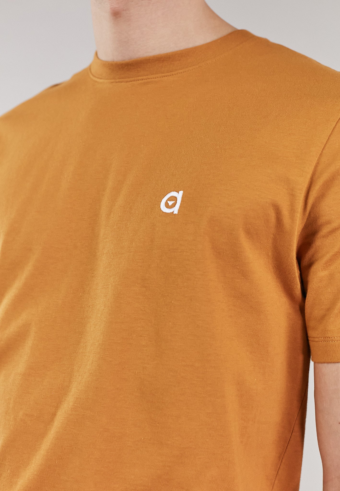 A rust low carbon t-shirt made from 100% organic cotton, featuring a regular fit and an embroidered altid logo.