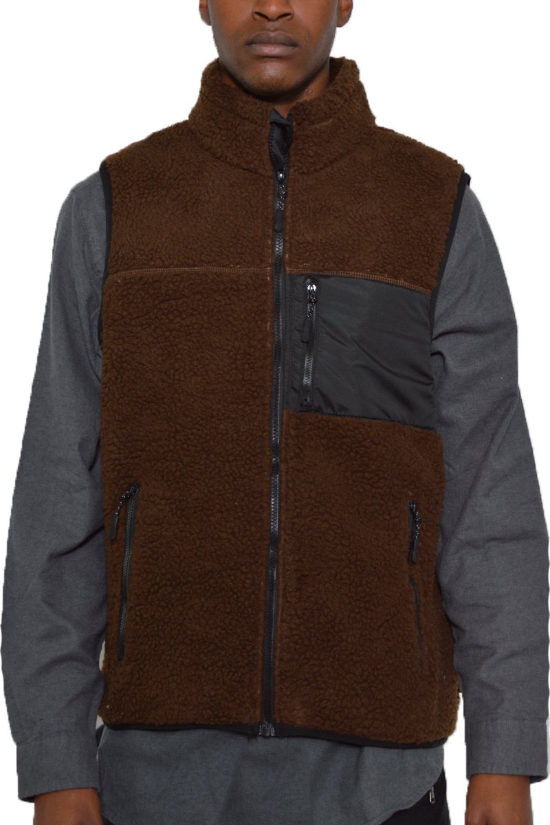 A cozy Sherpa fleece vest featuring a zip-up front and zippered pockets, perfect for layering in cold weather.