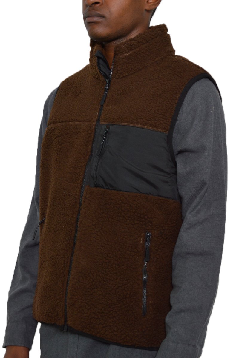 A cozy Sherpa fleece vest featuring a zip-up front and zippered pockets, perfect for layering in cold weather.