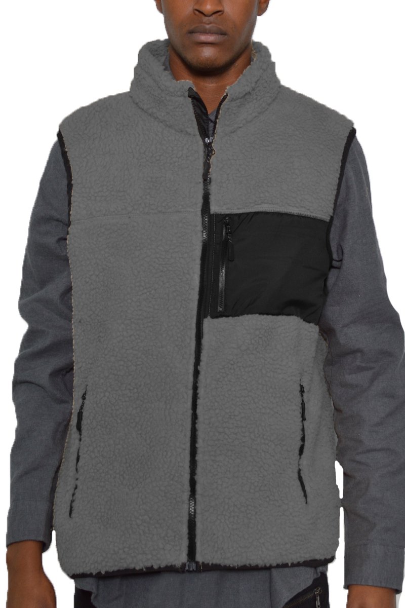 A cozy Sherpa fleece vest with a zip-up front, featuring a chest pocket and side zippered pockets, perfect for layering in cold weather.