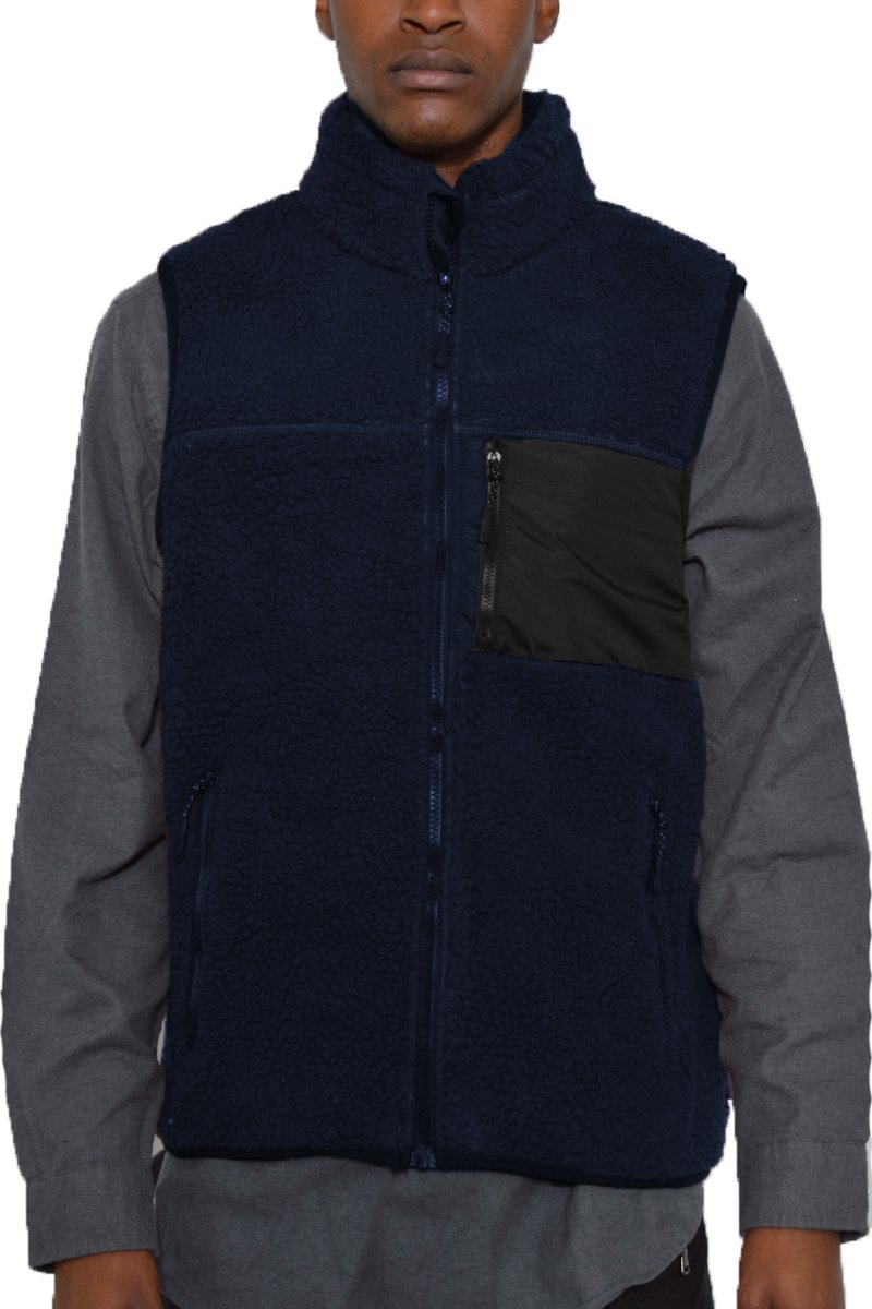 A cozy Sherpa fleece vest with a zip-up front, featuring a chest pocket and standard zippered side pockets, perfect for layering.