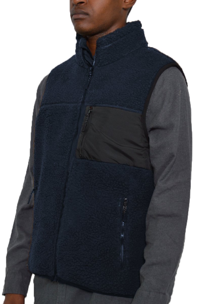 A cozy Sherpa fleece vest with a zip-up front, featuring a chest pocket and standard zippered side pockets, perfect for layering.