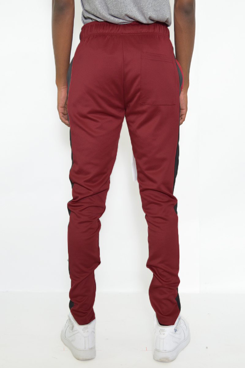 A pair of stylish slim fit track pants featuring a single stripe detail and hidden ankle zippers, perfect for workouts and casual wear.