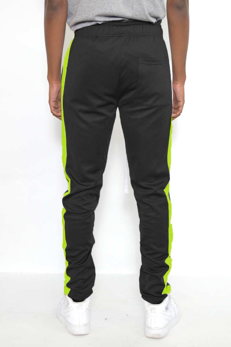 A pair of slim fit track pants featuring a single stripe detail, tug-free zipper closure, and hidden ankle zipper, displayed on a neutral background.