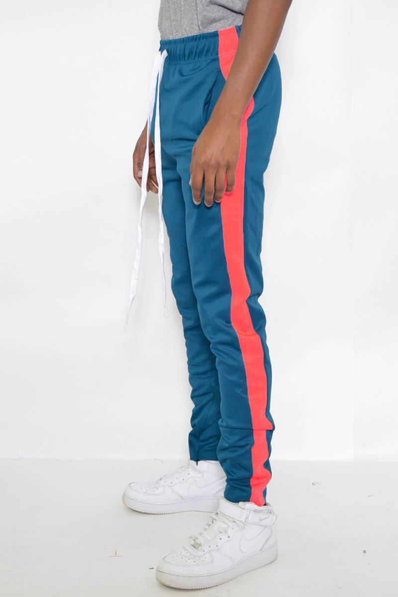 A pair of stylish slim fit track pants featuring a single stripe detail, tug-free zipper closure, and hidden ankle zippers, perfect for active wear.