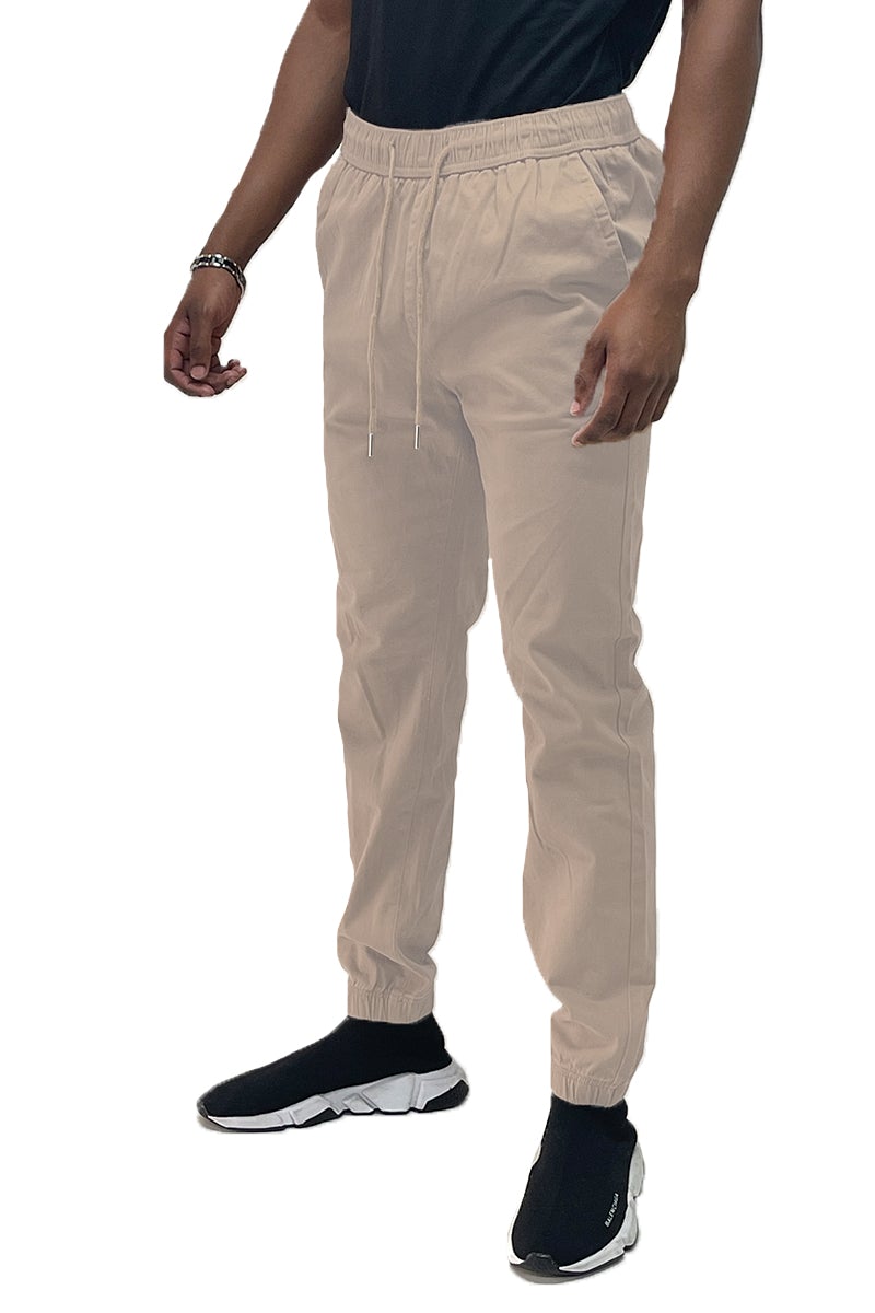 A pair of stylish solid jogger pants featuring an elastic waist and ankle, with standard and back pockets, made from a soft cotton blend.