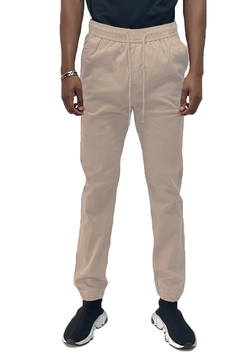 A pair of stylish solid jogger pants featuring an elastic waist and ankle, with standard and back pockets, made from a soft cotton blend.