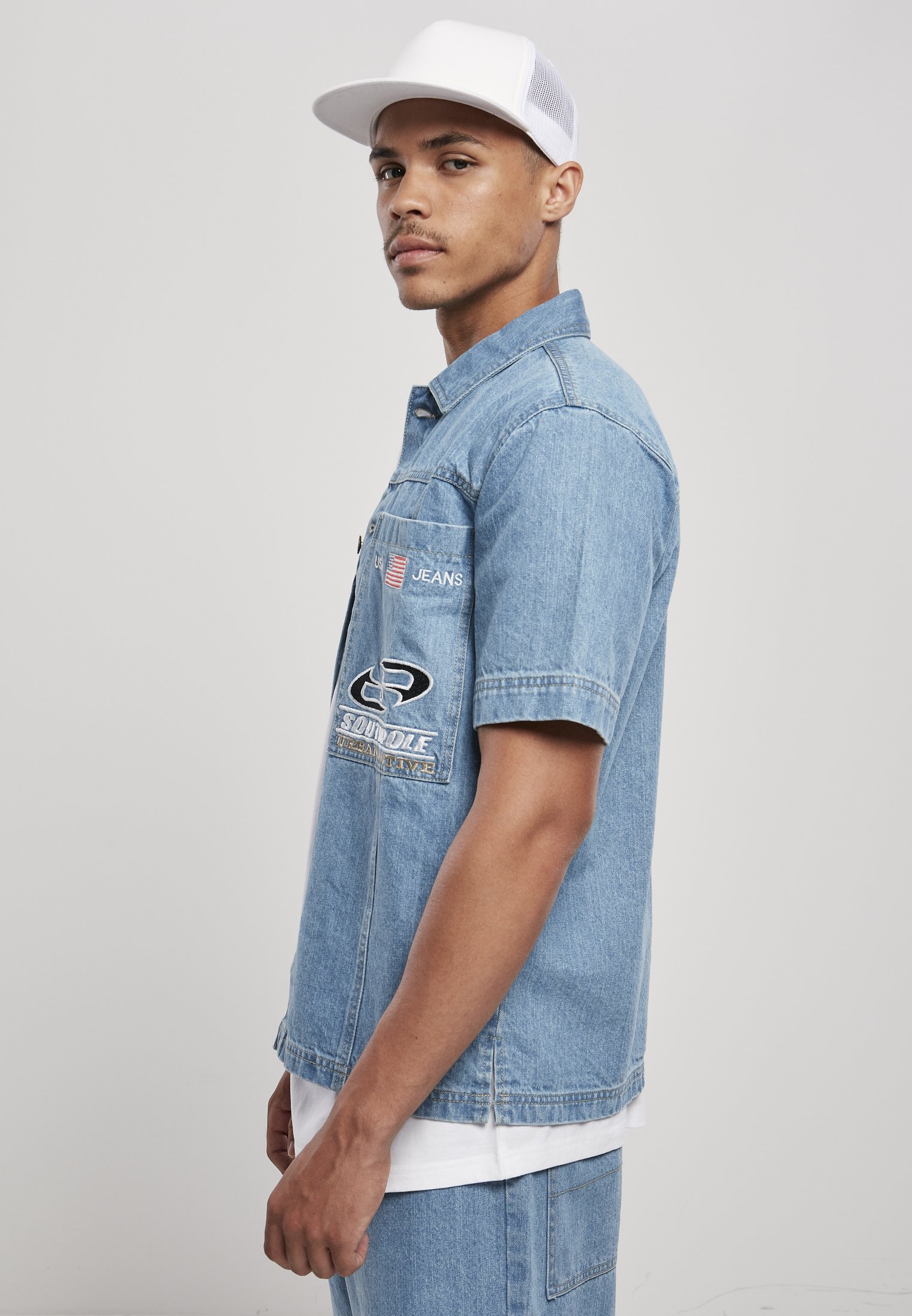 Men's Southpole Denim Shirt featuring button placket, turn-down collar, and large patch chest pockets with USA and Southpole logo embroidery.