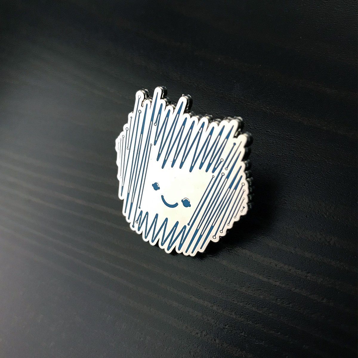 Sparky Enamel Pin featuring a blue and reflective silver design, round shape, and polished smooth finish.