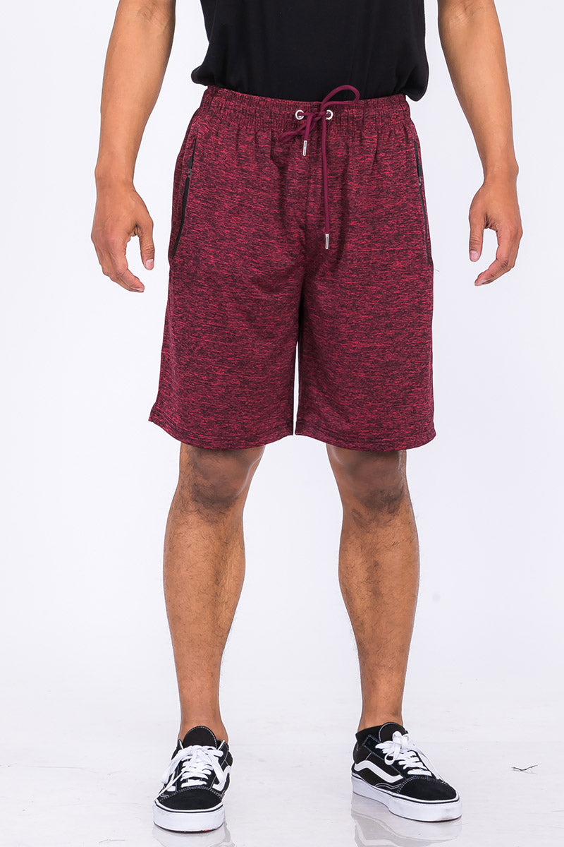 A pair of speckled performance shorts featuring an elastic waist, drawstring, and pockets, designed for comfort and mobility.