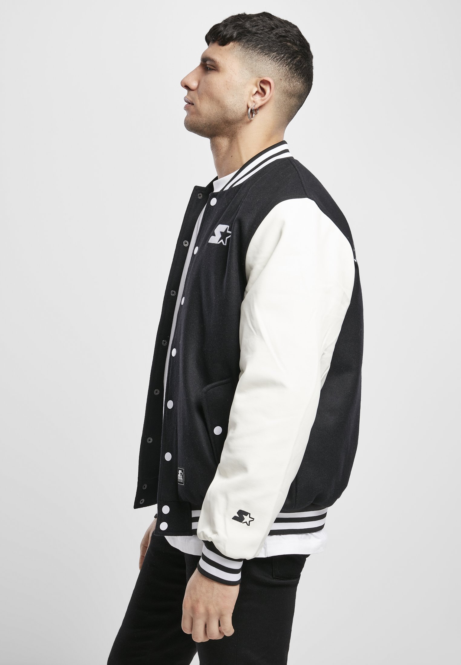 Standard College Jacket featuring a black body and white imitation leather sleeves, with double-striped cuffs and embroidered branding.