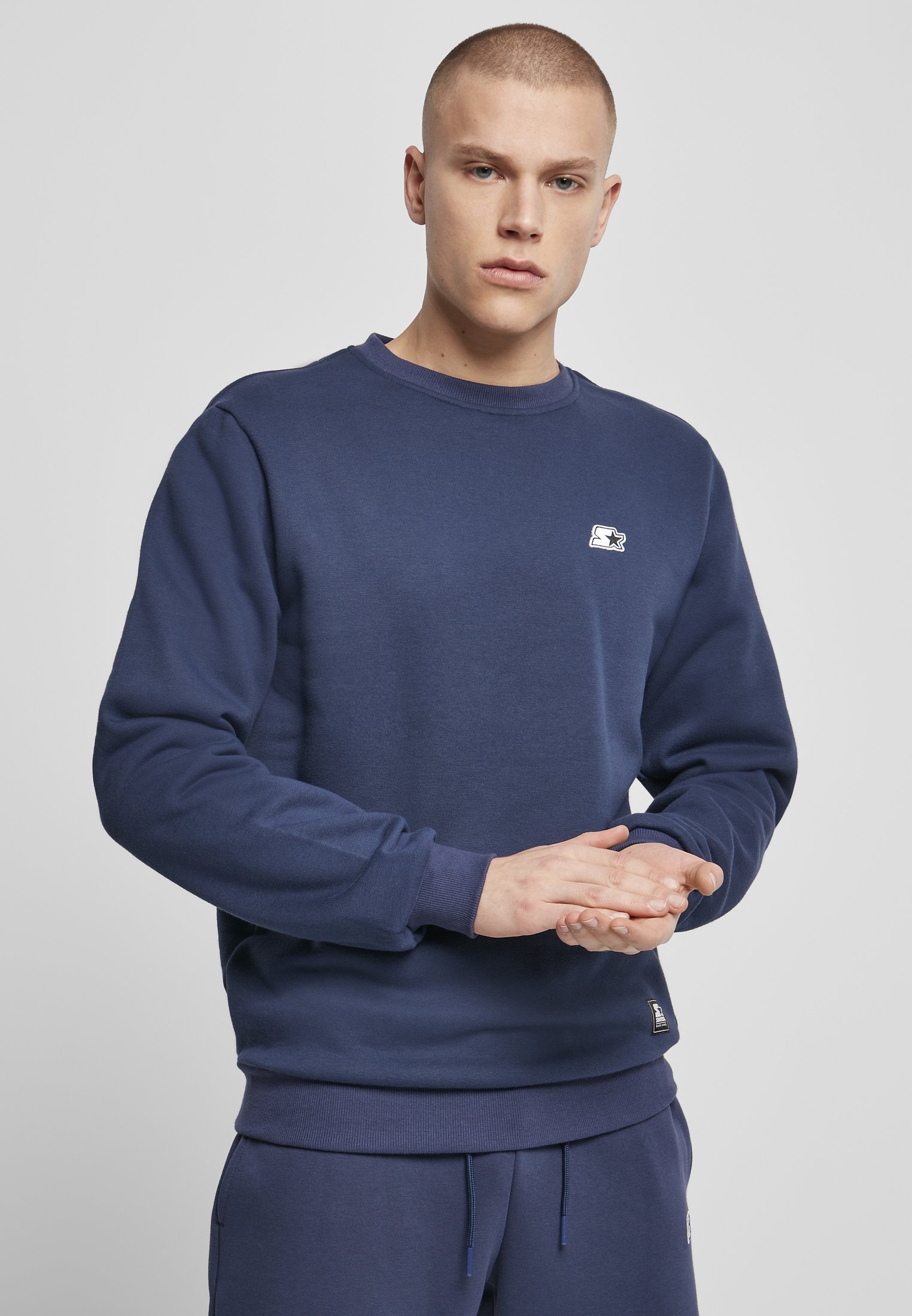 A cozy Starter Essential Crewneck Sweatshirt in various colors, showcasing its soft brushed fleece fabric and classic crewneck design.